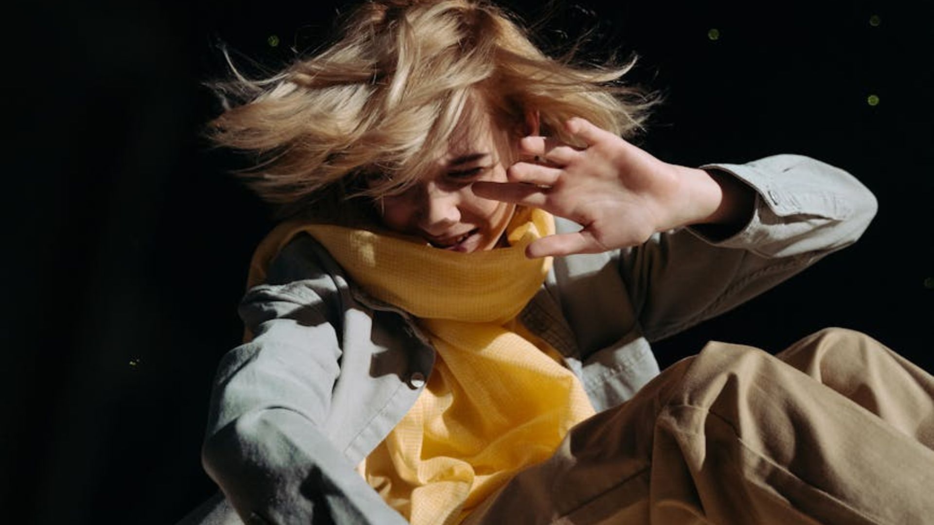 A person in dynamic motion against a dark, atmospheric background.