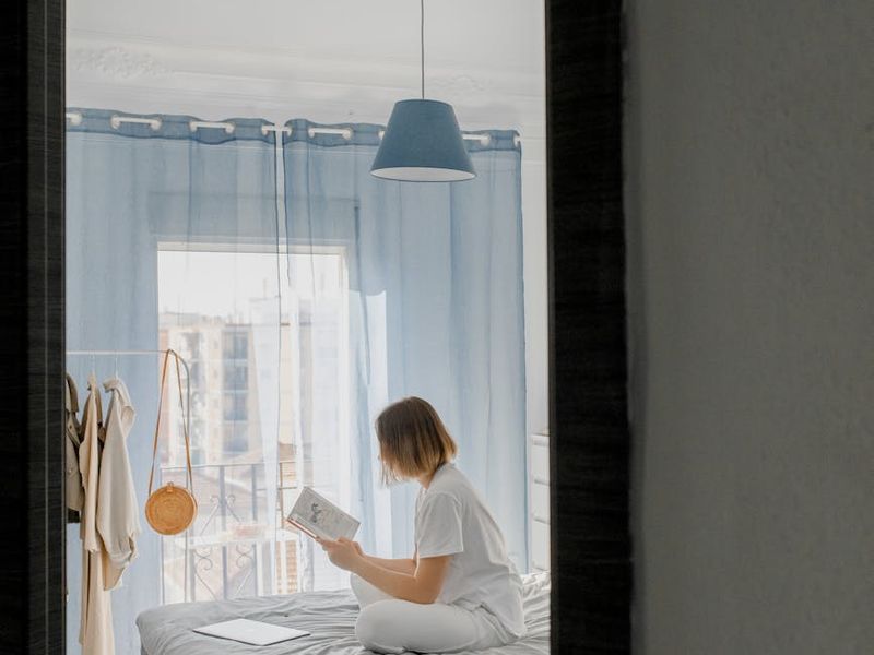 A person stretching in a minimalist room with blue light accents.